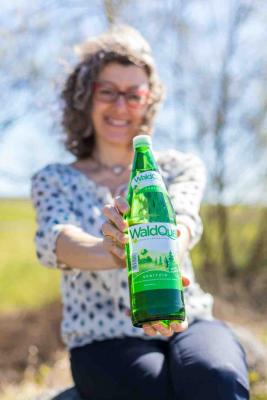 Monika Fiala, Geschäftsführerin Waldquelle, mit einer Waldquelle-Flasche im neuen Design