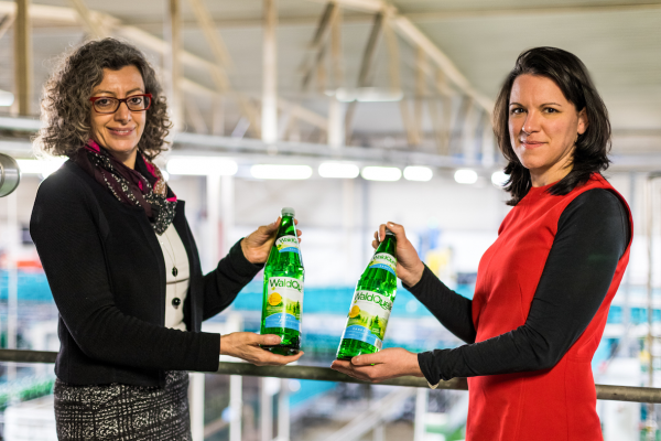 Waldquelle Geschäftsführerin Monika Fiala (links im Bild) und Dagmar Habeler, Waldquelle Marketing präsentieren das neue Glasflaschen-Etikett zum Jubiläum.
