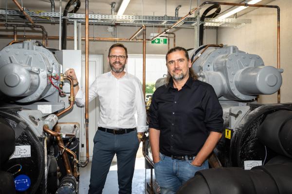 Dank einer neuen Wärmepumpenanlage stehen die Gaskessel im dm Verteilzentrum in Enns still. Im Bild v.l.n.r: Stefan Heiglauer (dm Geschäftsführer) und Johannes Staudecker (Abteilungsmanager Facility Management im dm Verteilzentrum Enns).